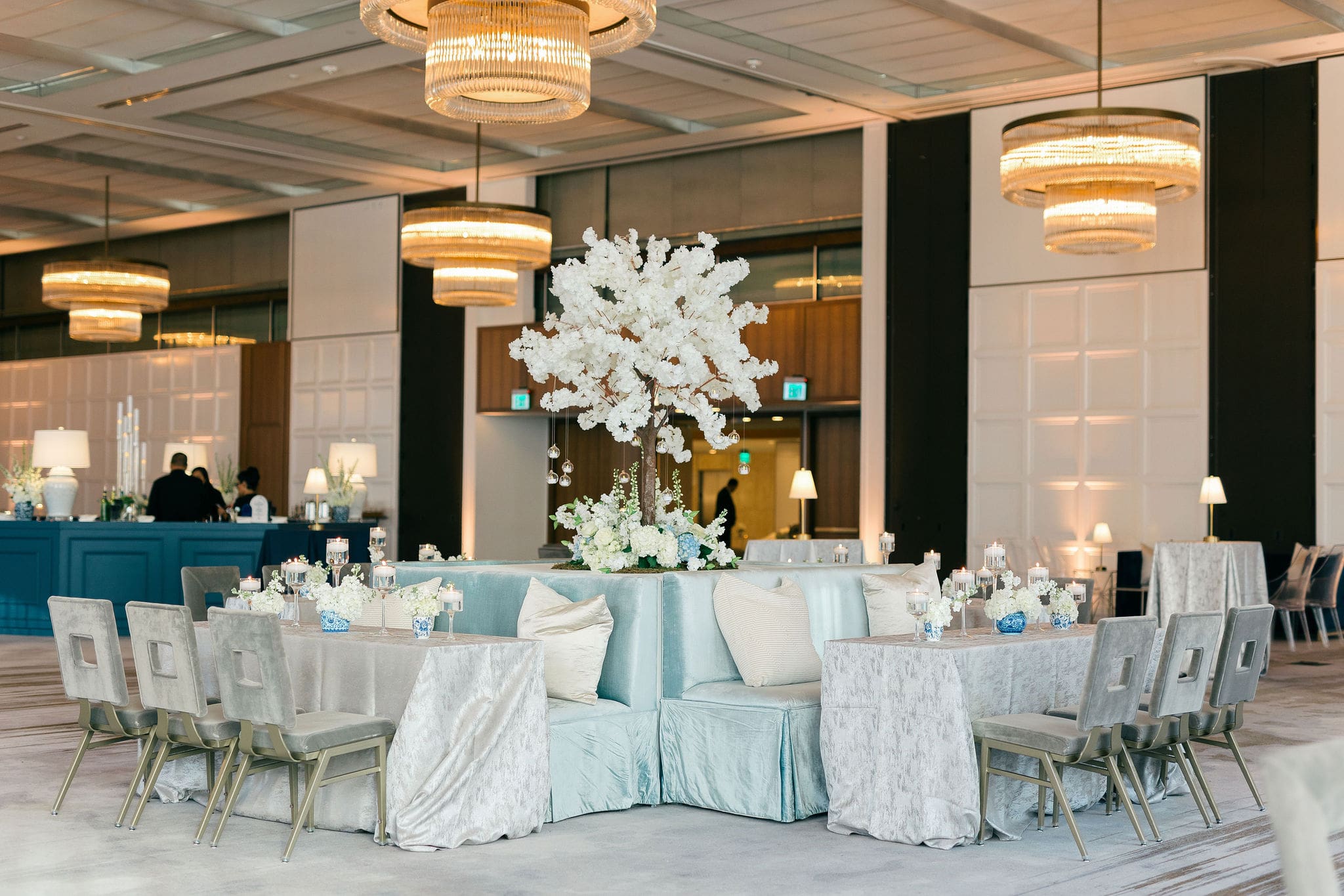 Elegant ballroom wedding reception with round tables, soft linens and chandeliers
