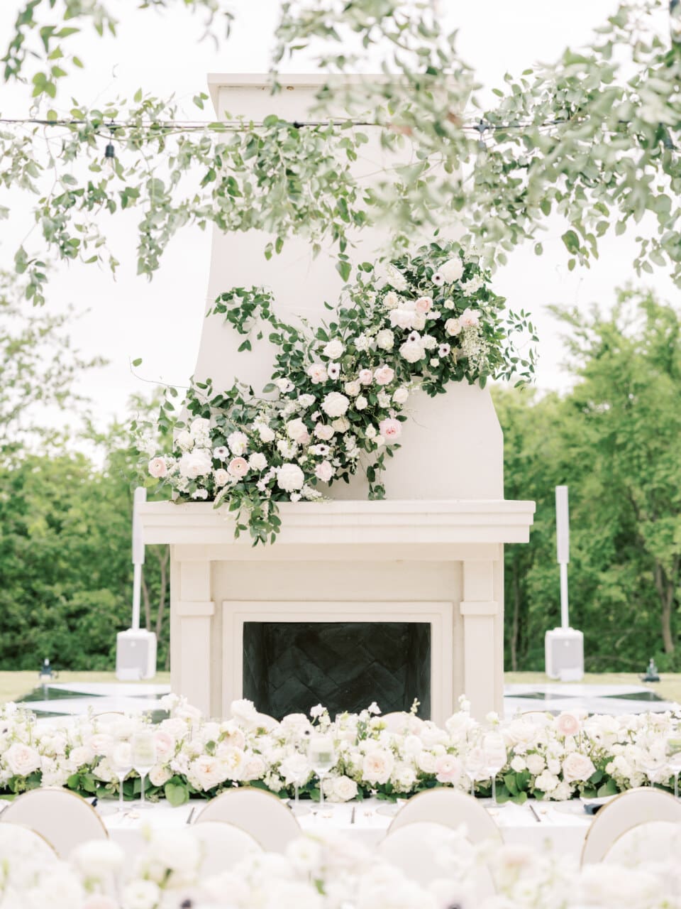 Ceremony backdrop with a grand stone fireplace framed by greenery
